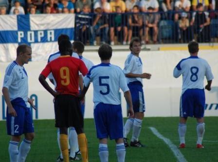 Suomi–Belgia-ottelussa Suomen valkopaitaiset pelaajat ja Belgian punapaitainen numero 9 kentällä, 11.08.2010