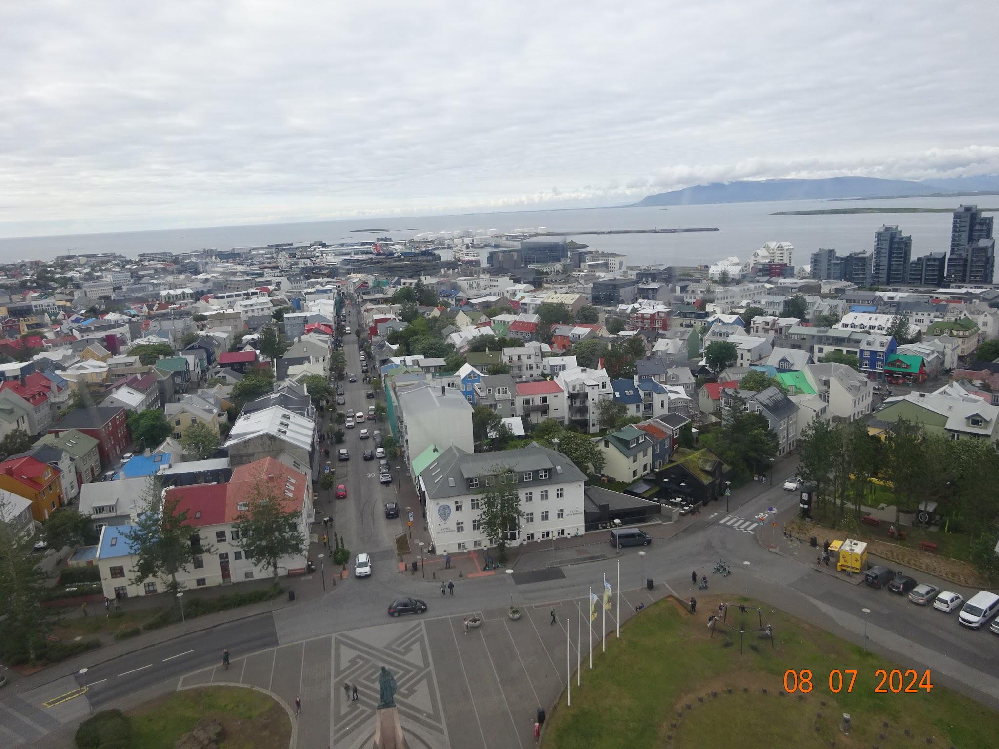 Näkymä Hallgrímskirkjan tornista Reykjavikin värikkäille kattoille, satamaan ja vuonolle, 08.07.2024
