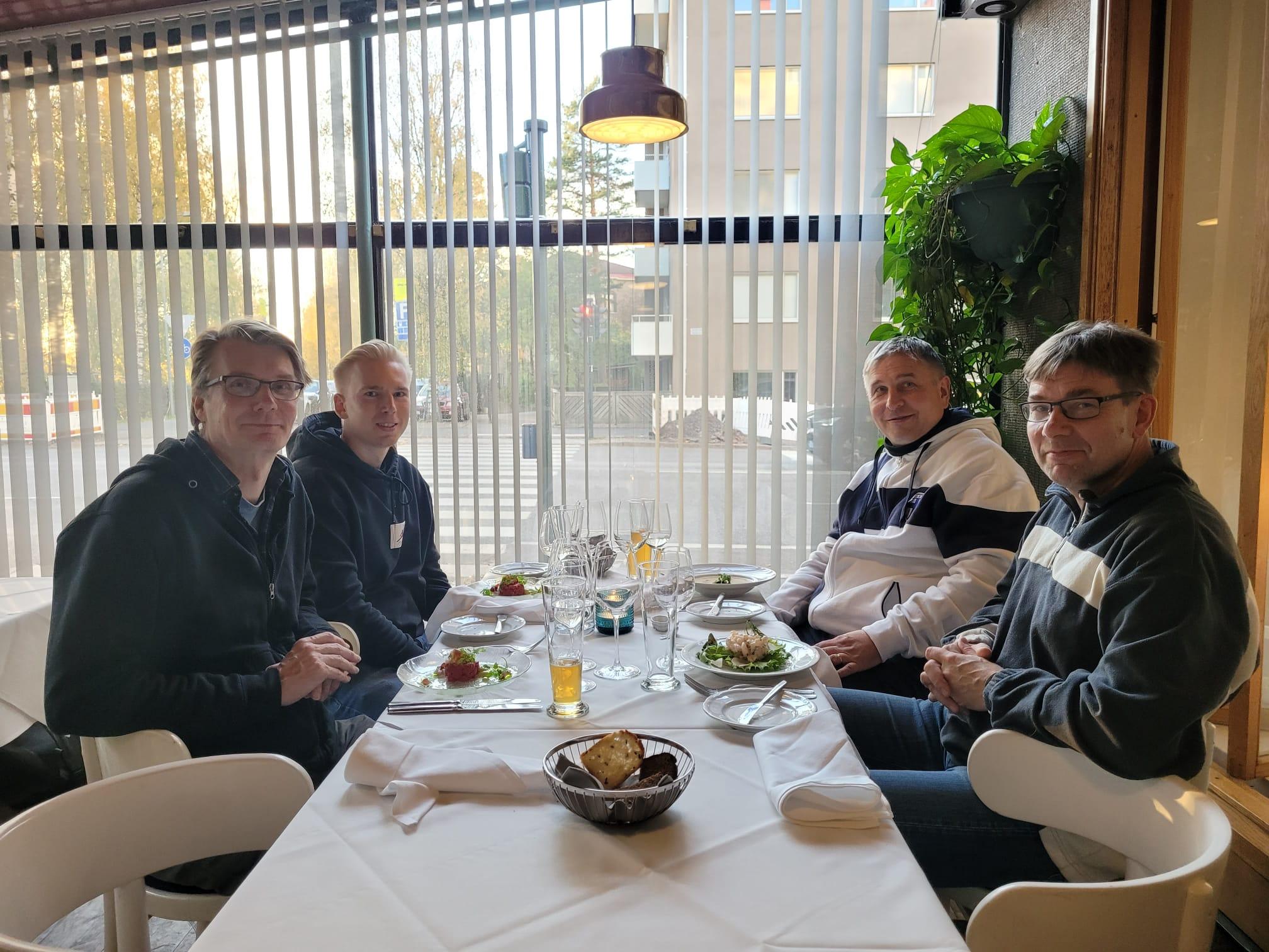 Neljä henkilöä katetun pöydän ääressä ravintola Lehtovaarassa Helsingissä ennen ottelua, 17.10.2023