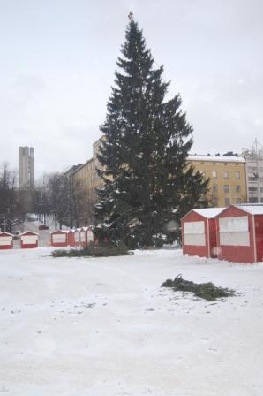 Suuri joulukuusi lumisella torilla, vieressä punaisia myyntikojuja, 24.12.2012
