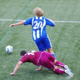 HJK–Schalke 04 -ottelussa sinivalkoraitainen pelaaja numero 20 ja kentälle kaatuva viininpunapaitainen vastustaja, 18.08.2011