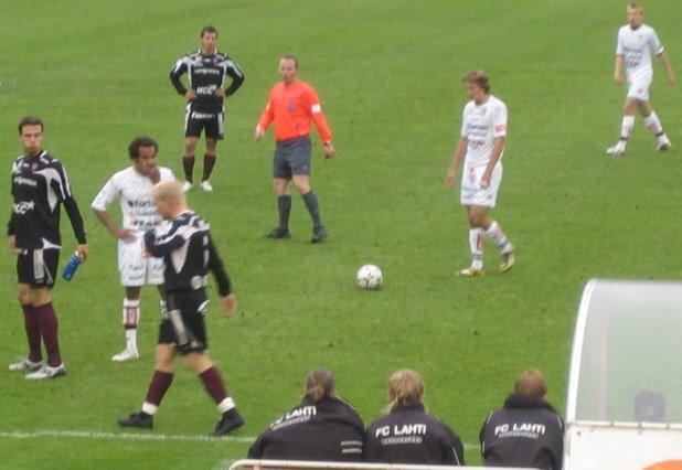 Pelaajat ja tuomari kentällä pelikatkolla, etualalla FC Lahti -takkeihin pukeutuneet vaihtopelaajat, 18.05.2008