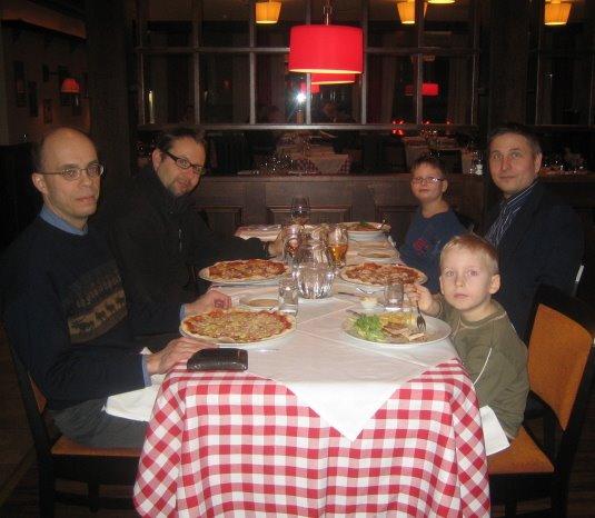 Klubilaiset pizza-aterialla punaruudullisen pöytäliinan ääressä ravintola Little Italyssä, 04.03.2008