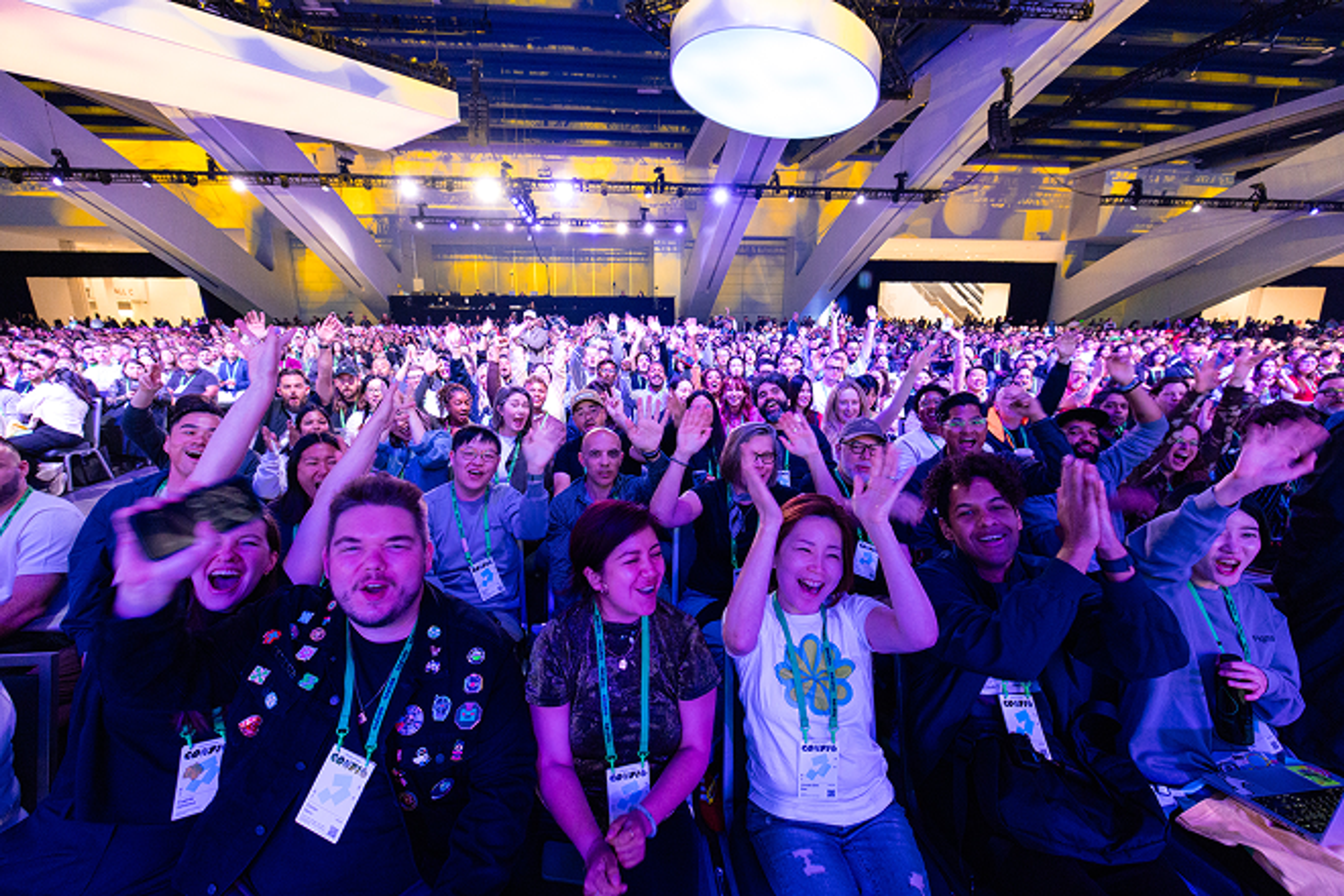Crowd of Config attendees with hands up cheering