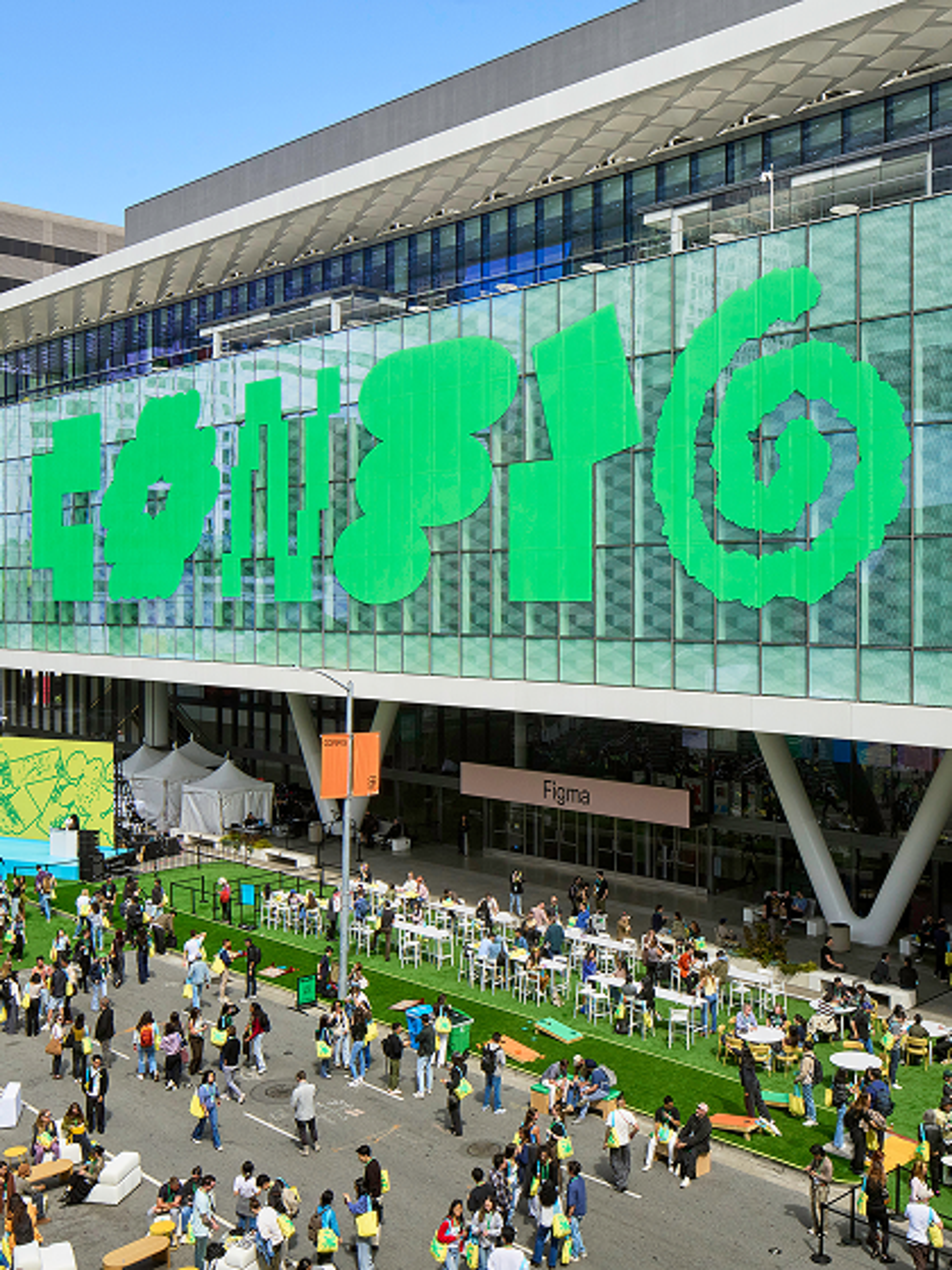 Large crowd gathered outside the Figma Config venue in front of a stage with a big logo on the building windows.