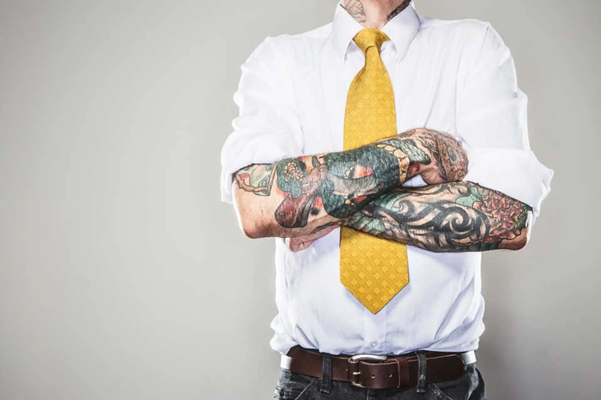 Mann med tatoveringer i businessklær