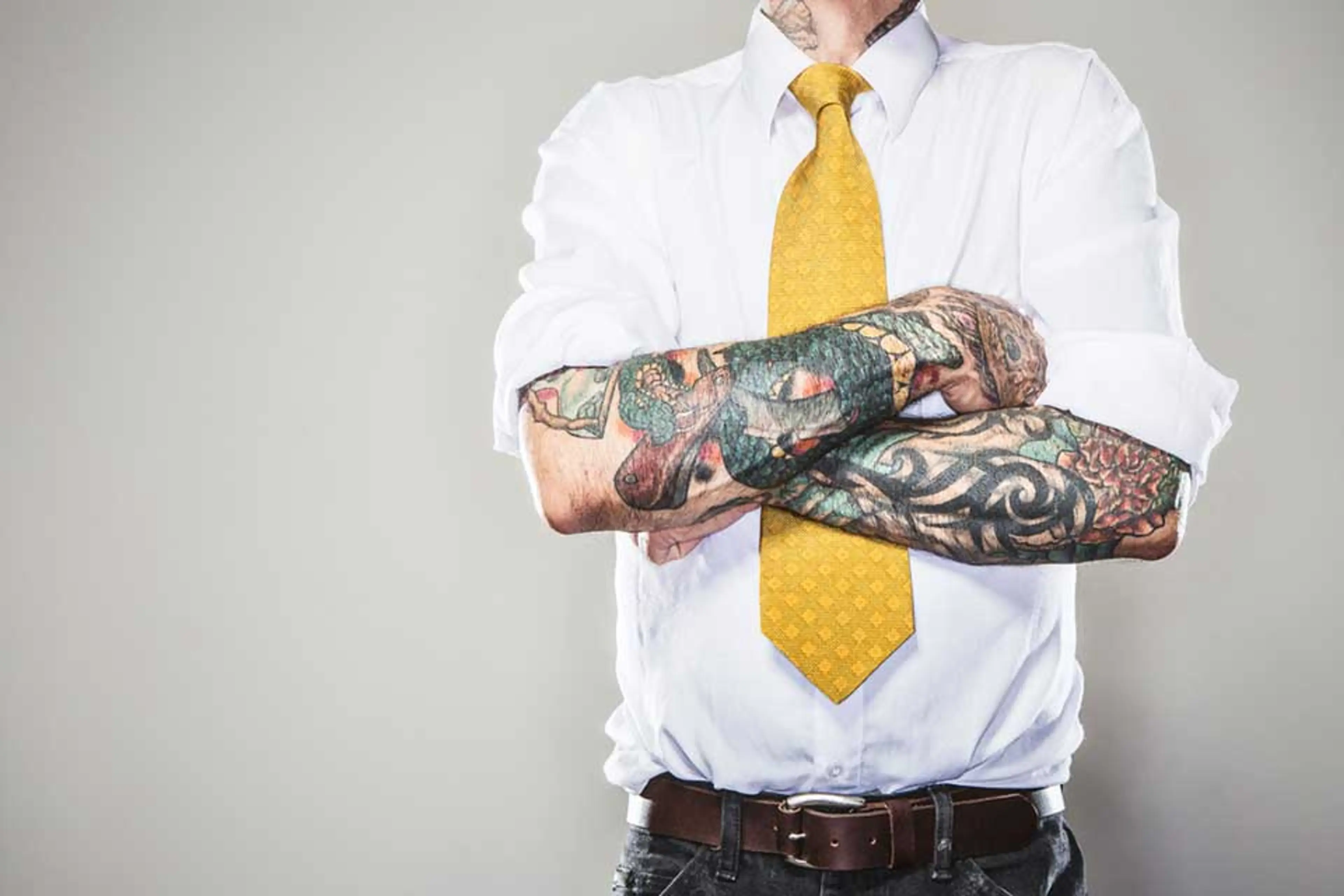 Mann med tatoveringer i businessklær