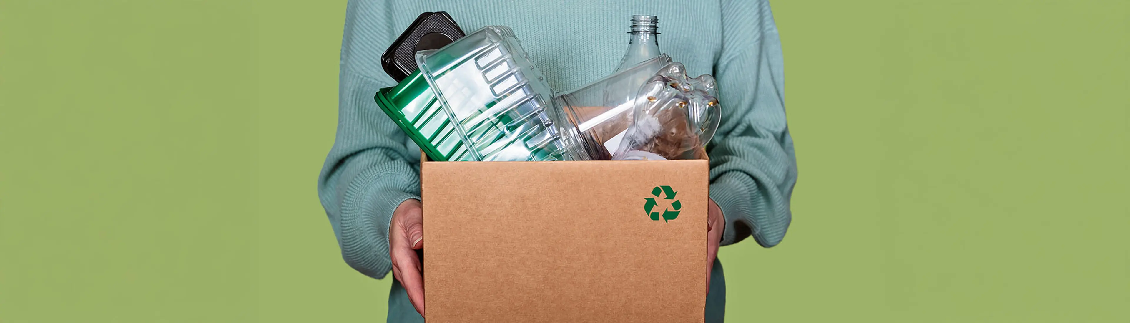 Dame som holder en pappeske med matemballasje til gjenvinning