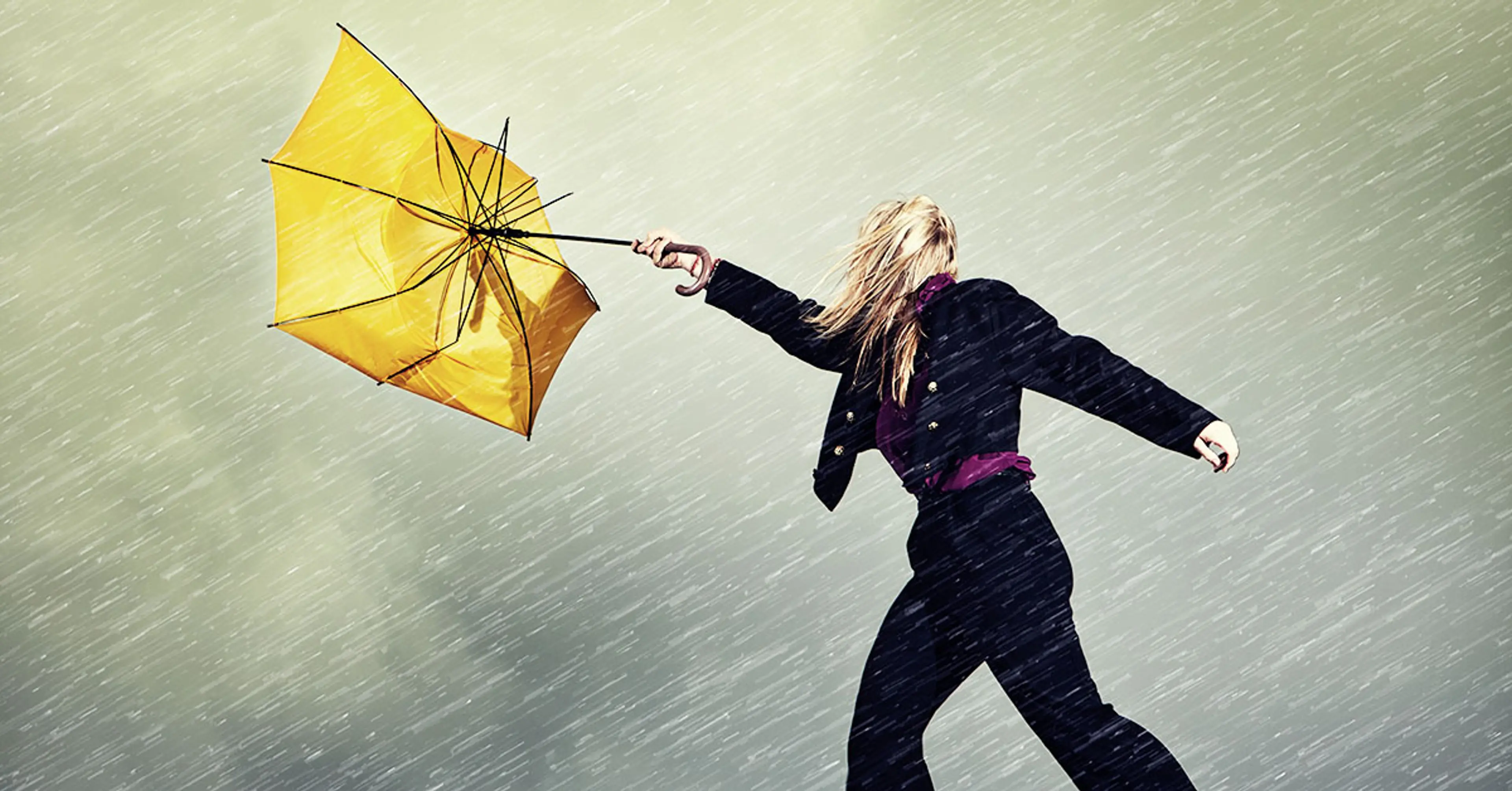 Dame i regnvær med vrengt paraply
