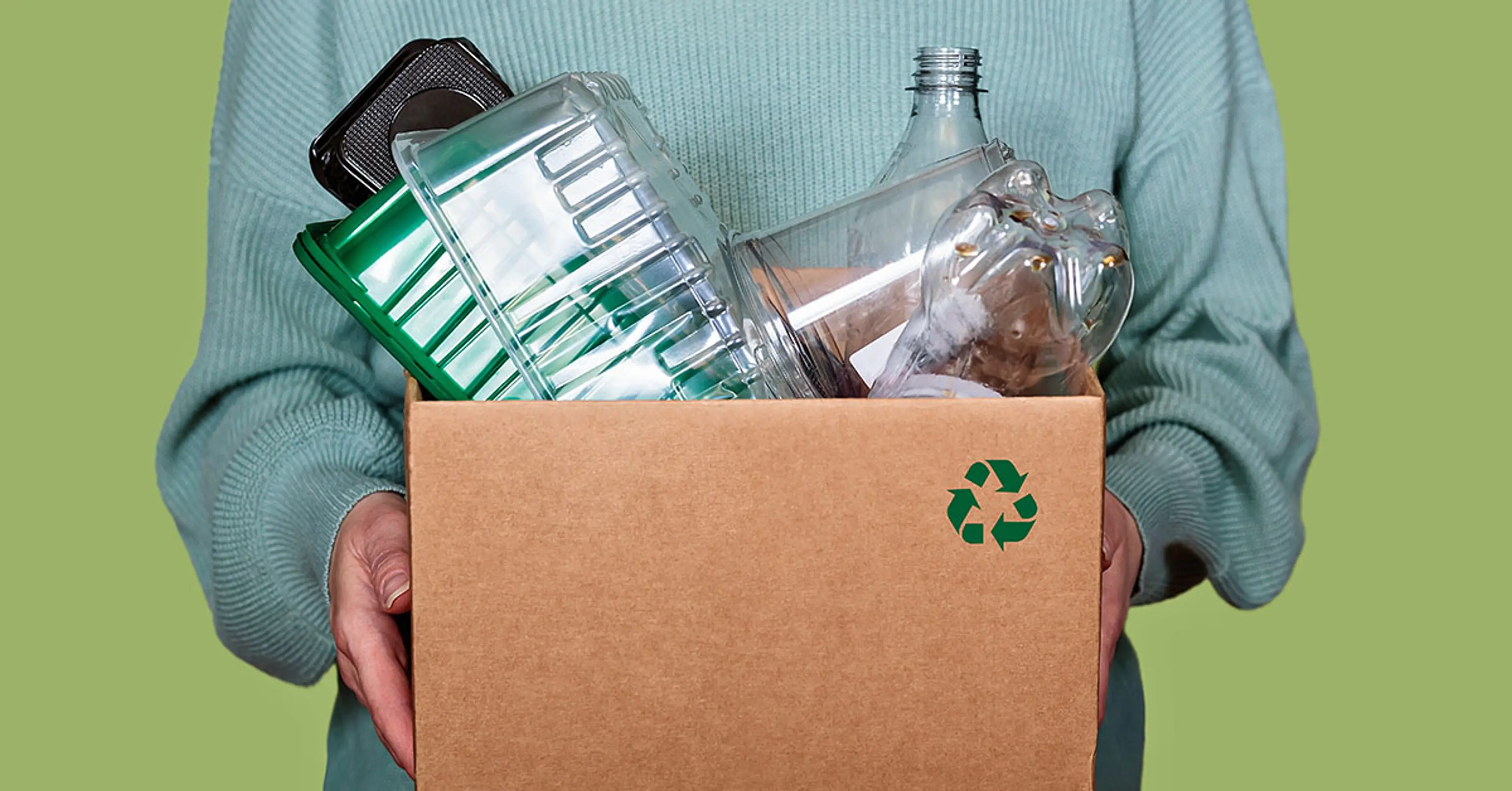 Dame som holder en pappeske med matemballasje til gjenvinning