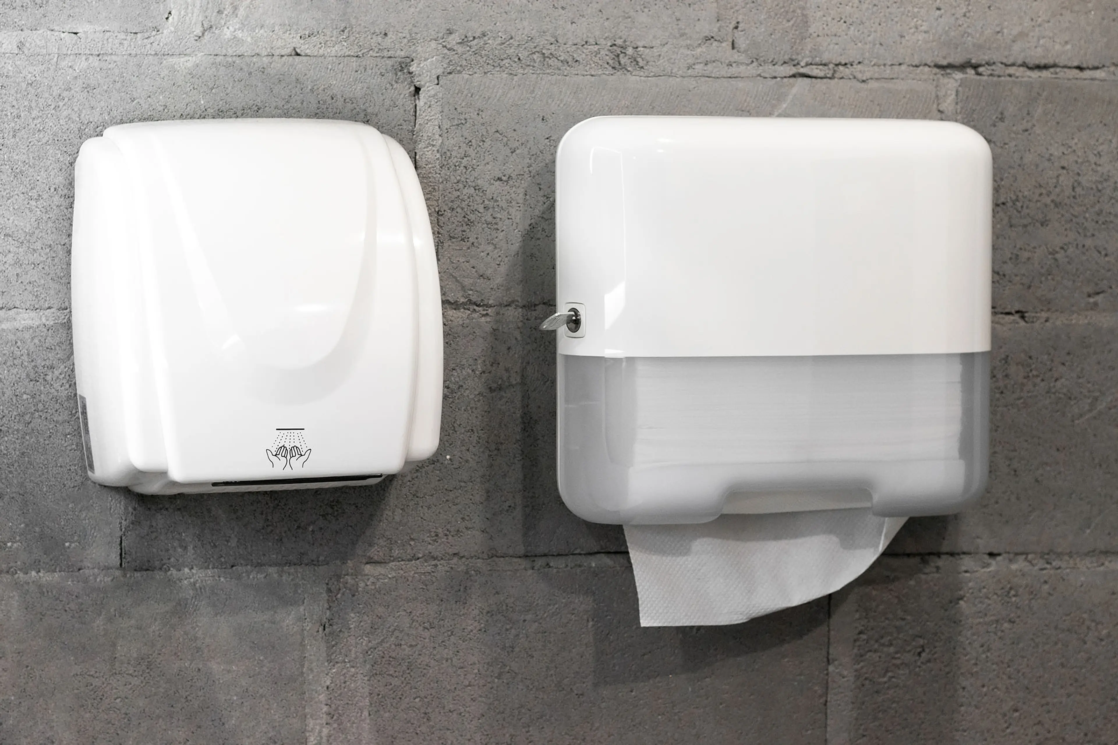 Lufttørker og dispenser med tørkepapir på offentlig toalett