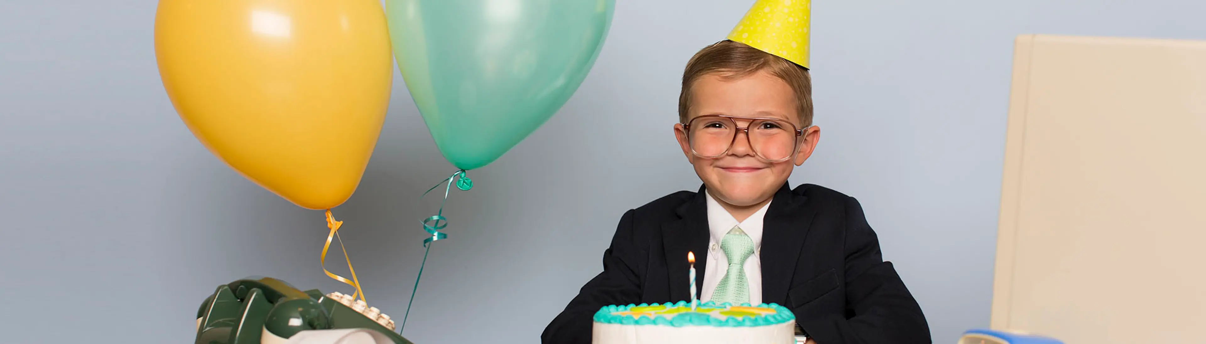 Gutt med ballonger og bursdagkake
