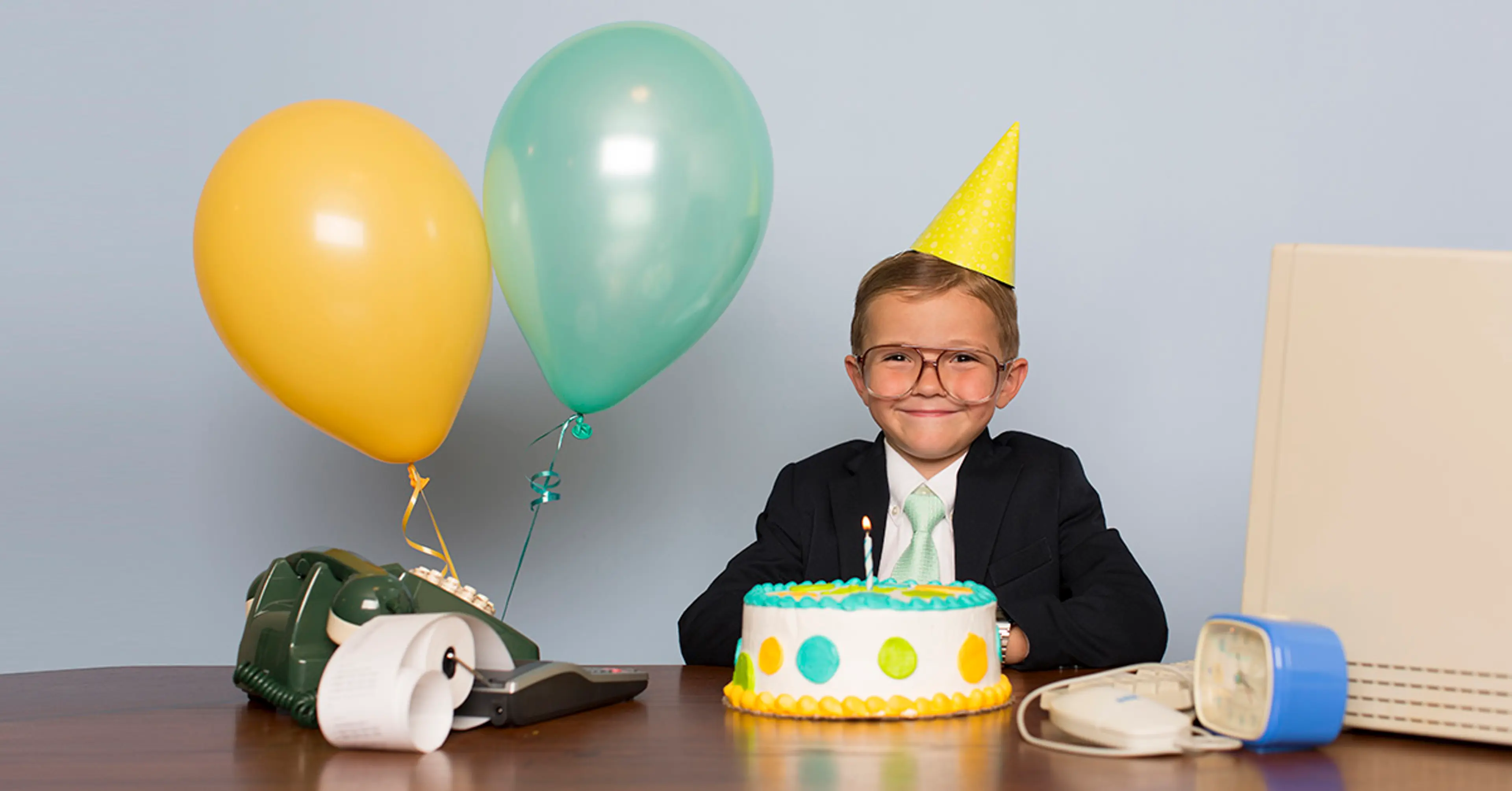 Gutt med ballonger og bursdagkake