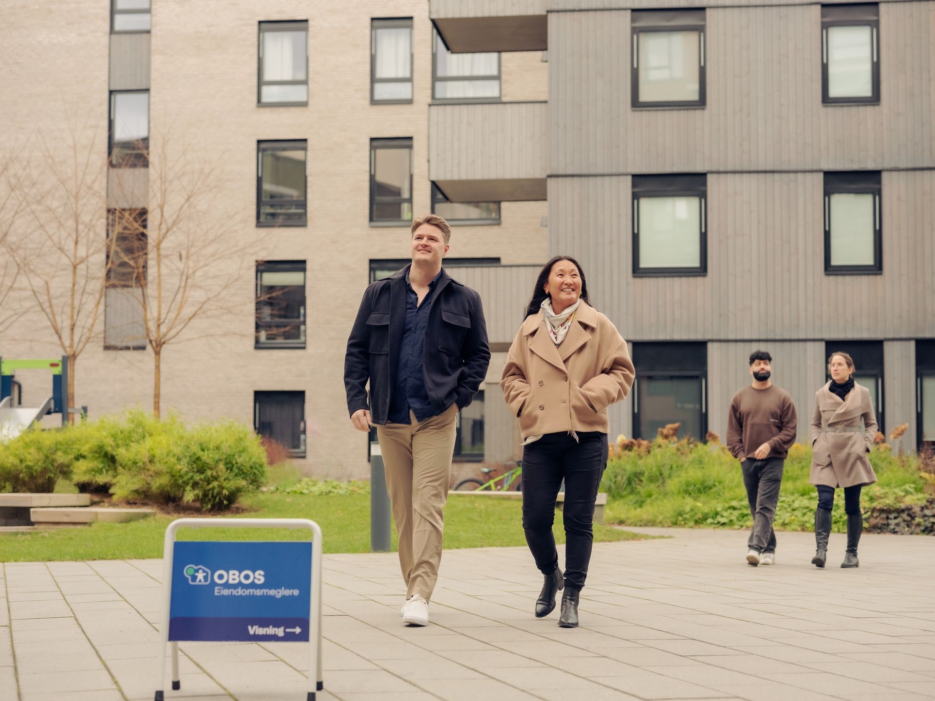 Et par som går og beundrer et boligprosjekt. Foto.