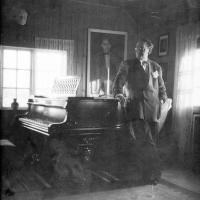 Trygve Stangeland framfor flygelet i stova i Mosberghagen. Foto: Karly Rosseland