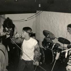 Hekkans første konsert ute, på Hansons Minde,april eller mai 1989.Inne i lokalet oste det av kåte og fulle og skrikende ungdommer. Utenfor sloss Tjensvollgjengen med Kristoffer Joner og hans gjeng.