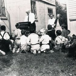 Franz Dørr demostrerer en gammel lirekasse for interesserte skolebarn utenfor Lagårdsveien 70. Bildet er tatt rundt 1950 da datteren Franziska hadde andre klasse ved Buøy skole. I bakgrunnen står Elsa og Gustine Dørr