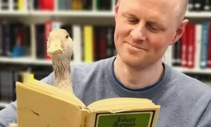 Åsmund Ådnøy leser bok med ei and