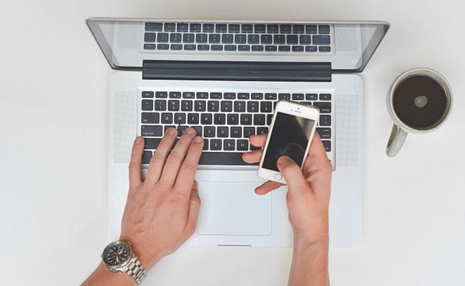 Hender på tastatur og mobiltelefon