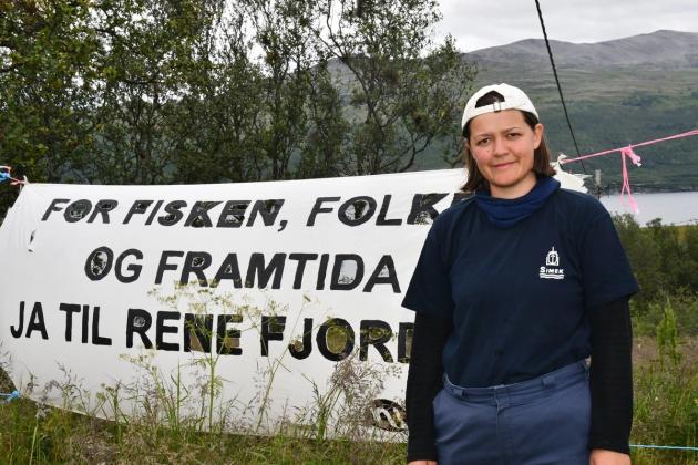 Maria Refsland foran banner med miljøprotest-slagord