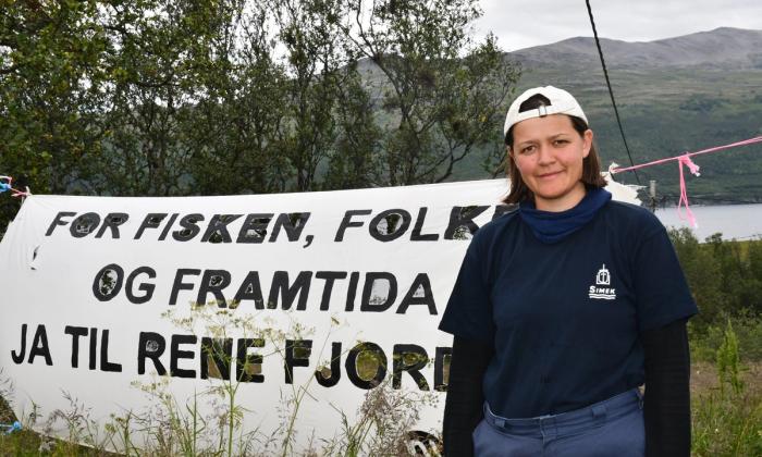 Maria Refsland foran banner med miljøprotest-slagord