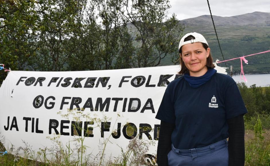 Maria Refsland foran banner med miljøprotest-slagord