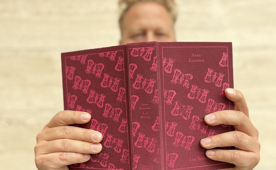 Tomas Gustafsson holder boken Anna Karenina foran ansiktet