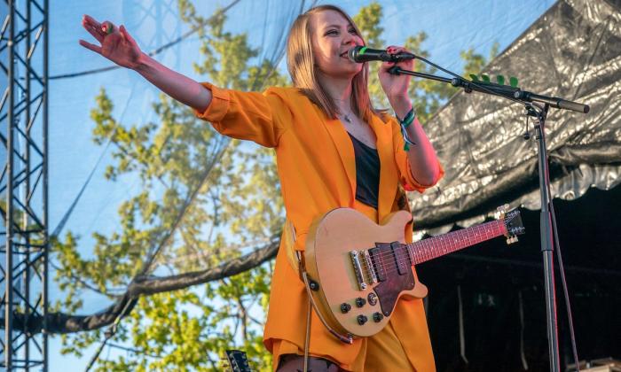 Sarah Hestness på scenen med gitar