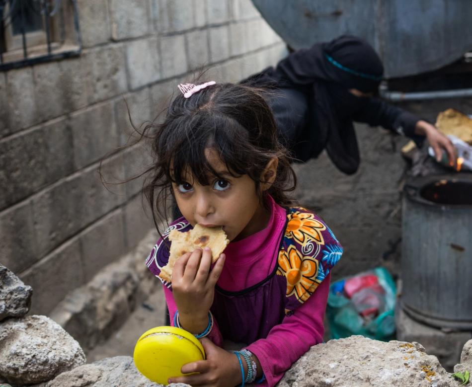 Jente spiser brød i Jemen