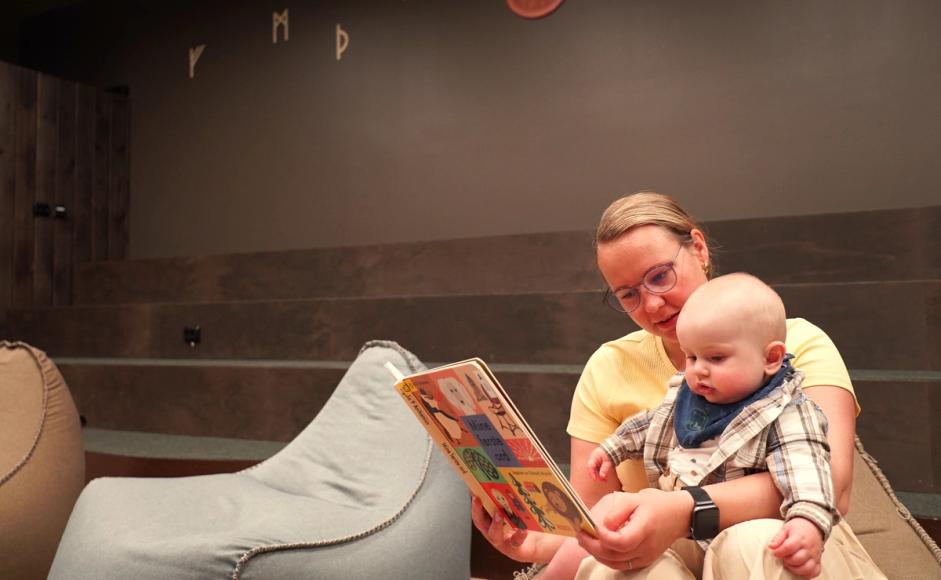 Mor leser for barnet sitt i pekebøker på Madla bibliotek.