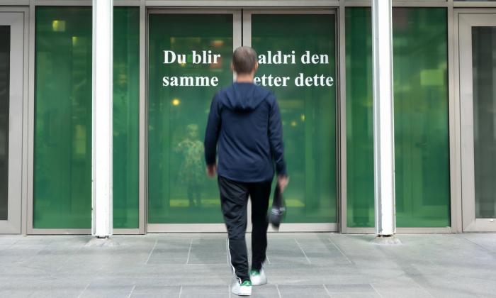Kunstverk av Kari Kalstø (37). Grønn folie på skyvedører ved Sølvbergets hovedinngang med teksten "Du blir aldri den samme etter dette"