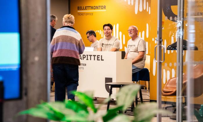 Frivillige og ansatte jobber i billettskranken.