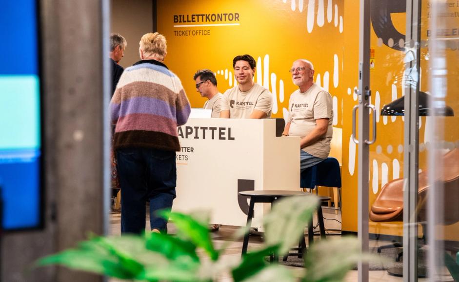 Frivillige og ansatte jobber i billettskranken.