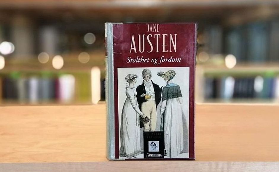 Stolthet og fordom av Jane Austen stående på bokhylle i biblioteket