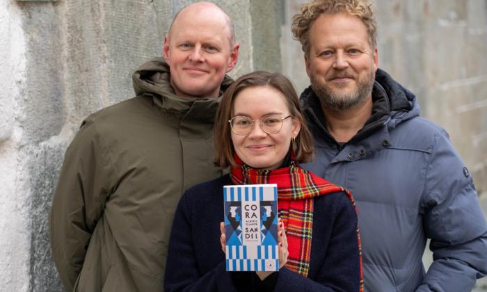 Åsmund Ådnøy, Ruth Stokke Haaland og Tomas Gustafsson med boka Alberte og Jakob av Cora Sandel