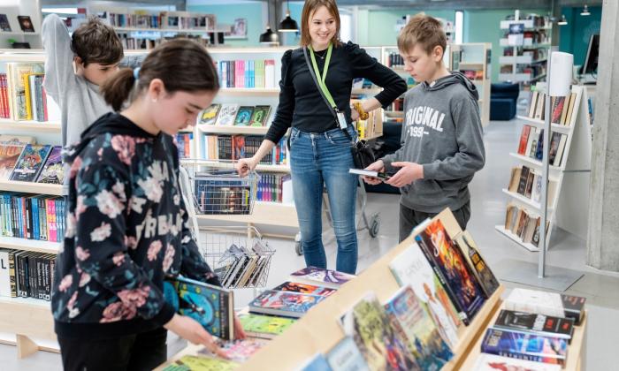 Bibliotekar Ingunn Øvrebø med barn i biblioteket