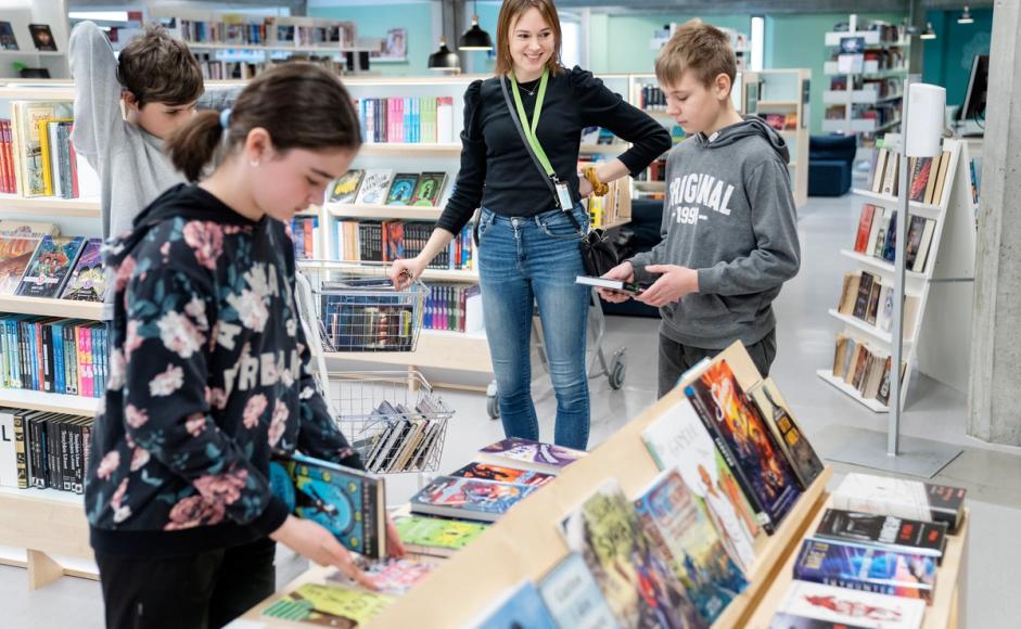 Bibliotekar Ingunn Øvrebø med barn i biblioteket