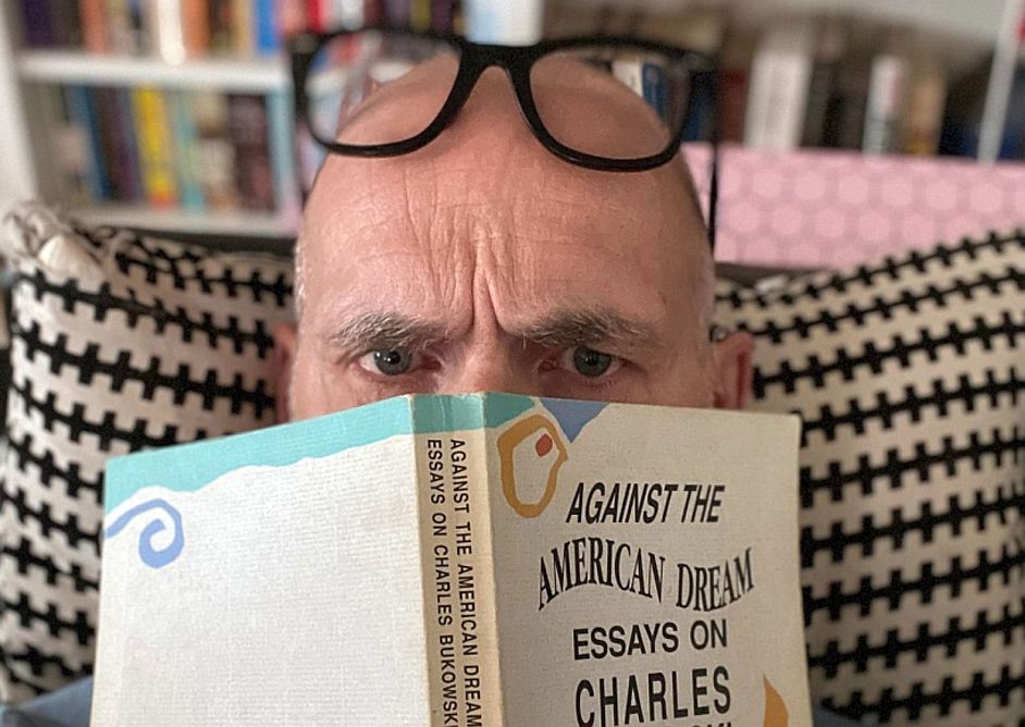 Tom H. Brekke med bok foran ansiktet