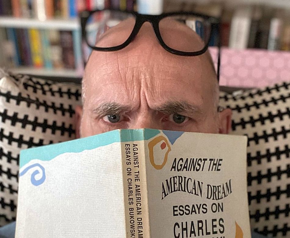 Tom H. Brekke med bok foran ansiktet.