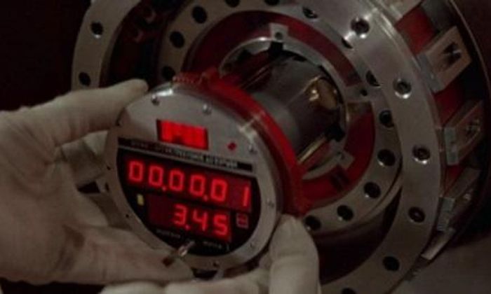 Hender som holder i en bombe med nedtellingsklokke