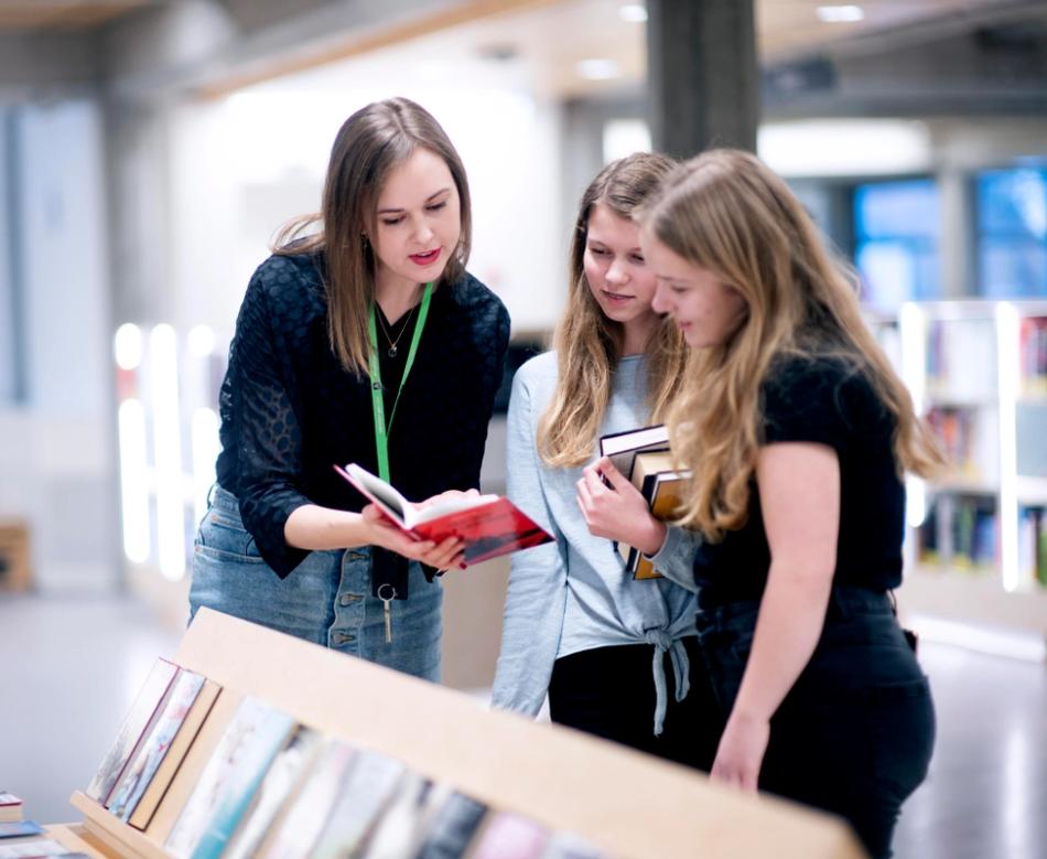 Bibliotekar, Ingunn Øvrebø, hjelper to unge jenter med å finne lesestoff