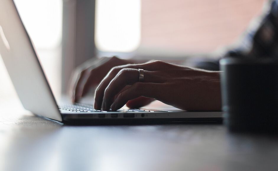 Hender som skriver på pc