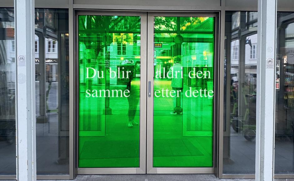 Kunstverk av Kari Kalstø (37). Grønn folie på skyvedører ved Sølvbergets hovedinngang med teksten "Du blir aldri den samme etter dette"