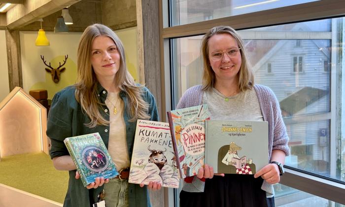 Maria og Rebekka viser frem bøker i barnebiblioteket.