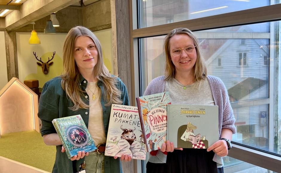 Maria og Rebekka viser frem bøker i barnebiblioteket.
