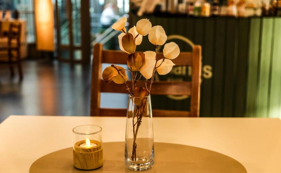 Foto av bord med lys og blomster i Kiellands kafé