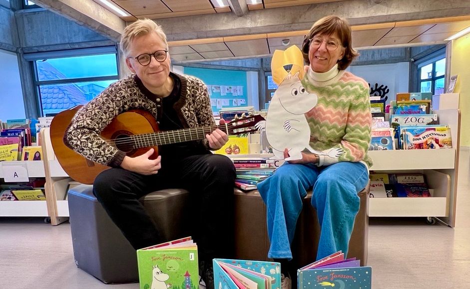 Foto av Ebbe Helberg og Eli Gunn Buvik som viser bøker og mumitrollet med bursdagskrone