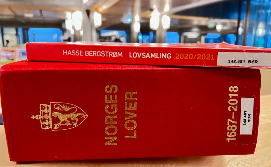 Norges lover og lovsamling liggende på en bokhylle