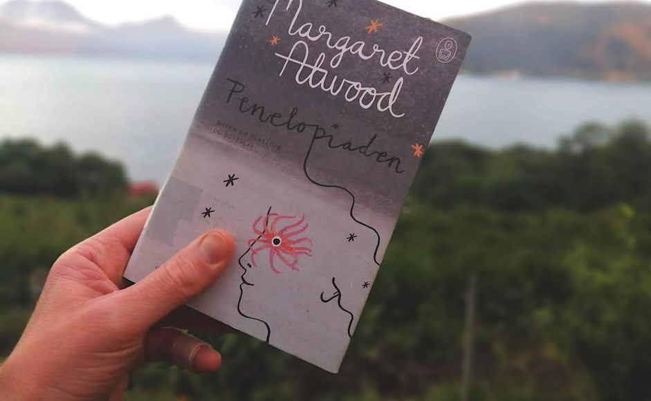 Penelopiaden av Margaret Atwood holdt foran en fjord