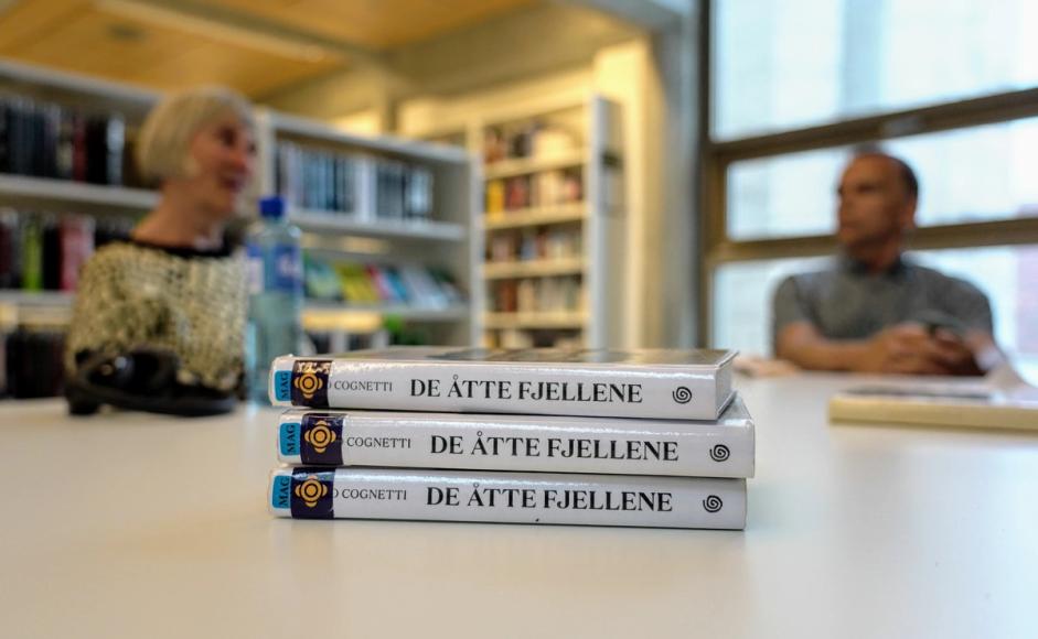 To personer som sitter ved et hvitt bord og snakker om bøker